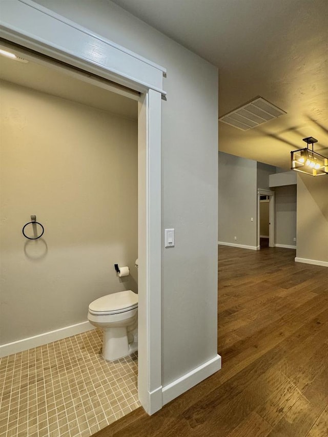 bathroom with wood-type flooring and toilet