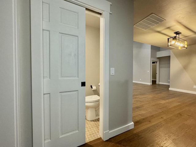 interior space with hardwood / wood-style flooring and toilet