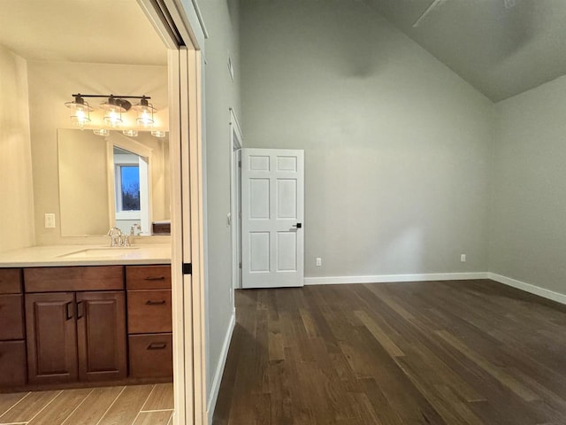 bathroom featuring hardwood / wood-style floors, vanity, and vaulted ceiling