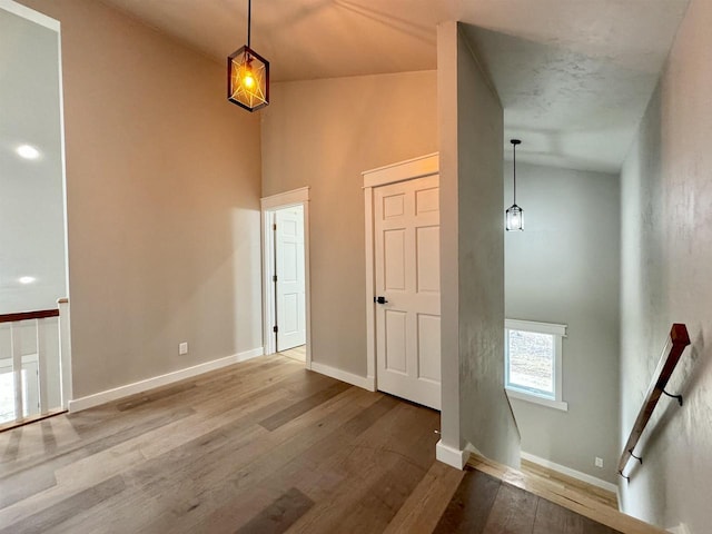 hallway featuring hardwood / wood-style flooring and vaulted ceiling