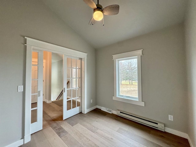 empty room with ceiling fan, french doors, a baseboard radiator, and vaulted ceiling