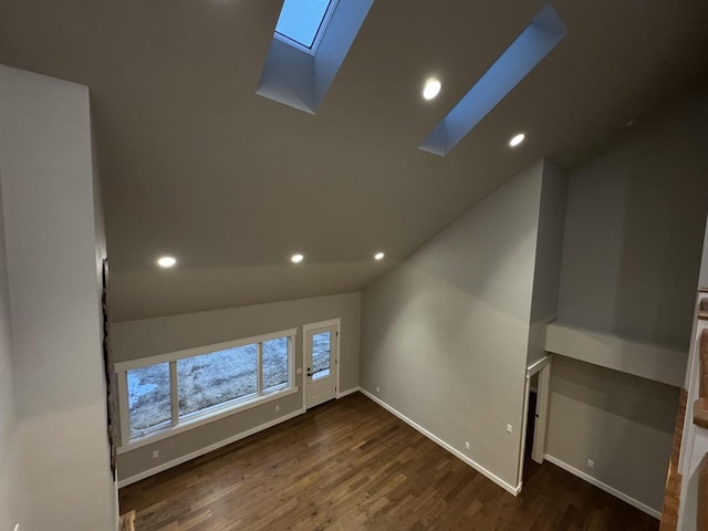 interior space with lofted ceiling with skylight and dark wood-type flooring