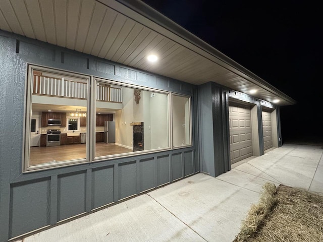 garage at night featuring stainless steel fridge