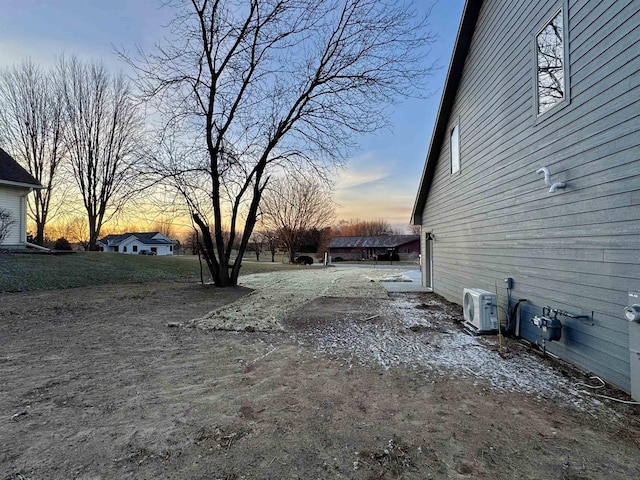 yard at dusk featuring ac unit