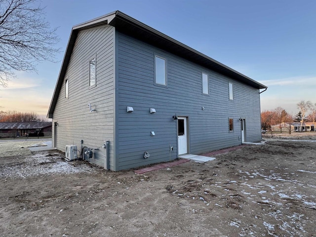 back house at dusk with central AC unit