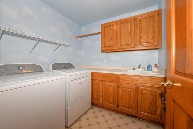 laundry room featuring cabinets, washer and clothes dryer, and sink