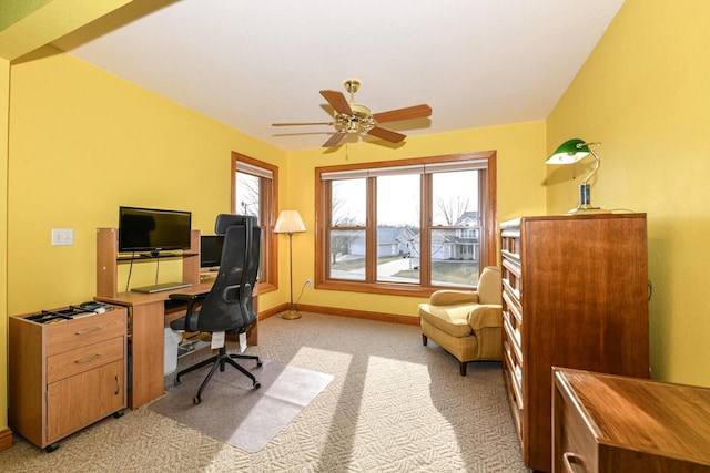 carpeted home office featuring ceiling fan