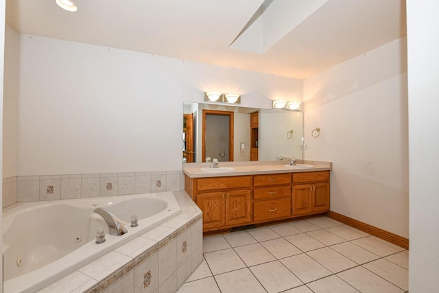 bathroom featuring tile patterned flooring, vanity, and tiled tub