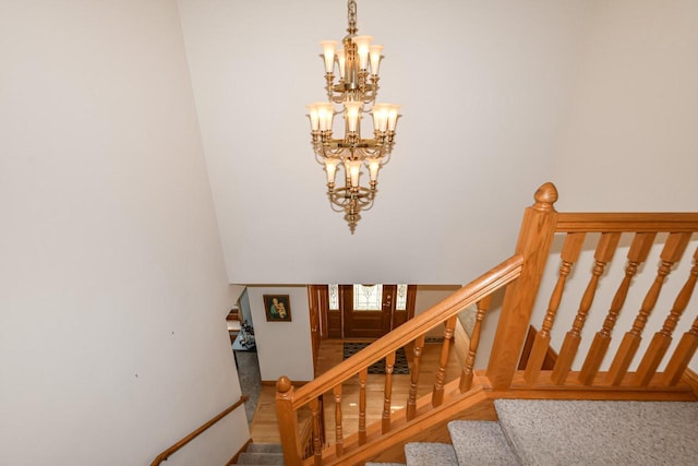 staircase with a notable chandelier