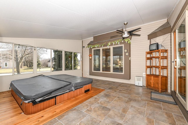 sunroom / solarium with a jacuzzi and ceiling fan