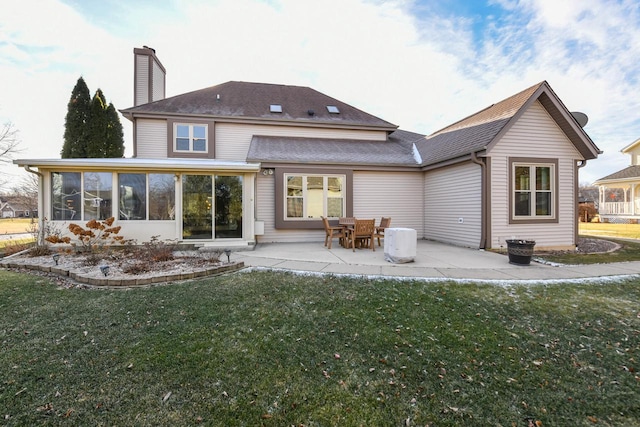 back of house with a sunroom, a patio area, and a lawn