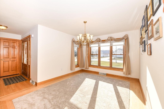 unfurnished dining area with hardwood / wood-style flooring and a chandelier