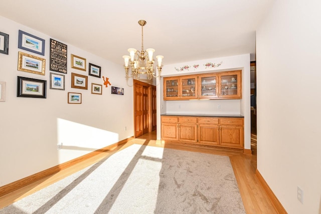 hall with a notable chandelier and light wood-type flooring