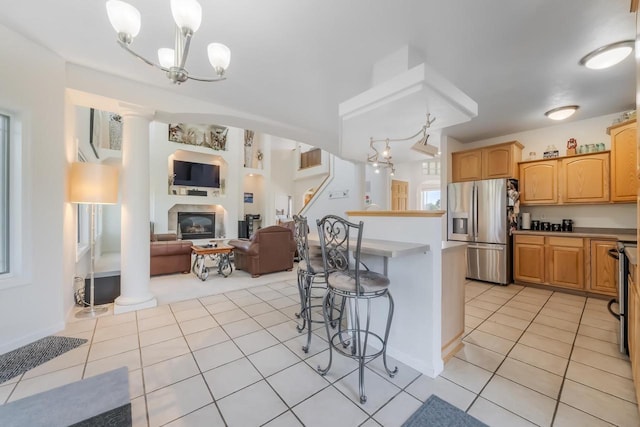 kitchen featuring pendant lighting, stainless steel fridge, a breakfast bar area, and an inviting chandelier