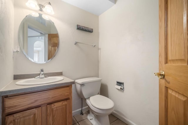 bathroom with toilet, vanity, and tile patterned floors