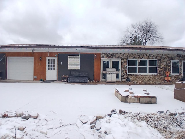 snow covered property with a garage