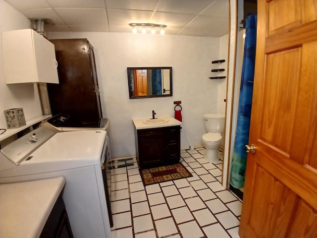 bathroom featuring washer and clothes dryer, vanity, a paneled ceiling, tile patterned flooring, and toilet