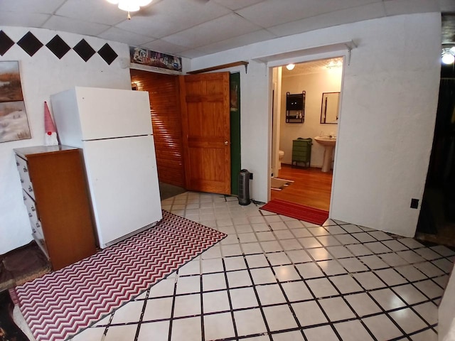 kitchen with white refrigerator and a drop ceiling