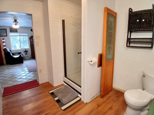 bathroom featuring hardwood / wood-style flooring, toilet, walk in shower, and ceiling fan