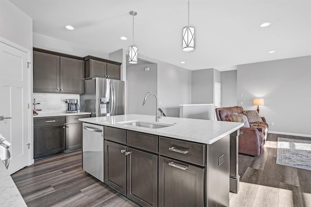 kitchen featuring decorative light fixtures, stainless steel appliances, dark wood-type flooring, and sink