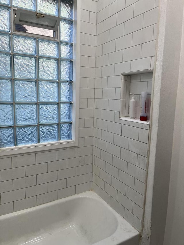 bathroom featuring plenty of natural light and tiled shower / bath combo