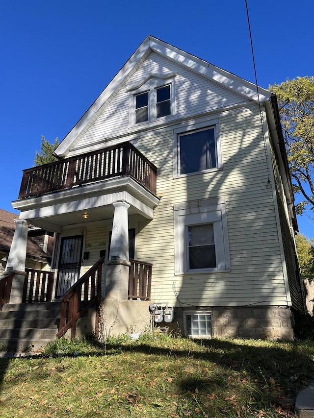 rear view of property with covered porch and a balcony