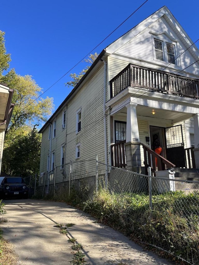 view of side of home featuring a porch and a balcony