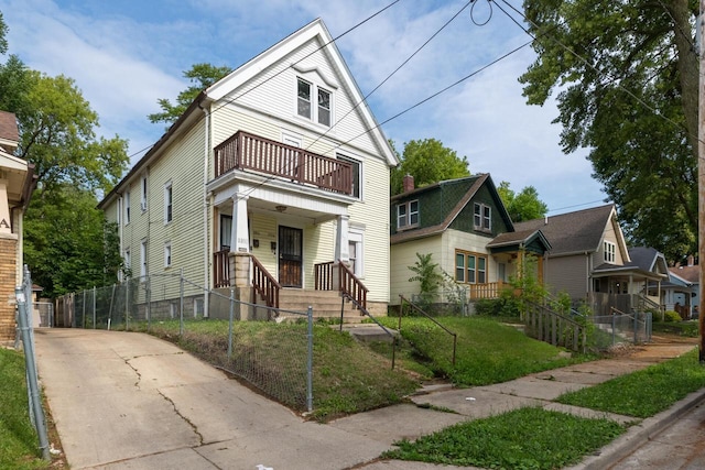 view of front of property with a balcony and a front lawn