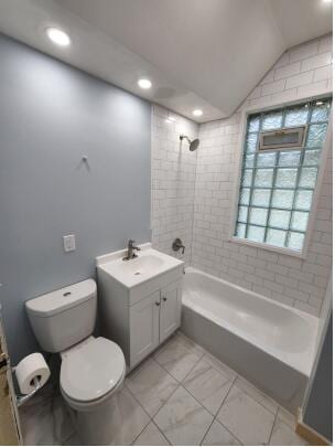 full bathroom with vanity, toilet, tiled shower / bath, and vaulted ceiling