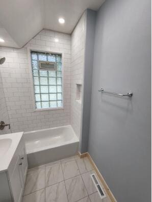 bathroom with vanity and tiled shower / bath