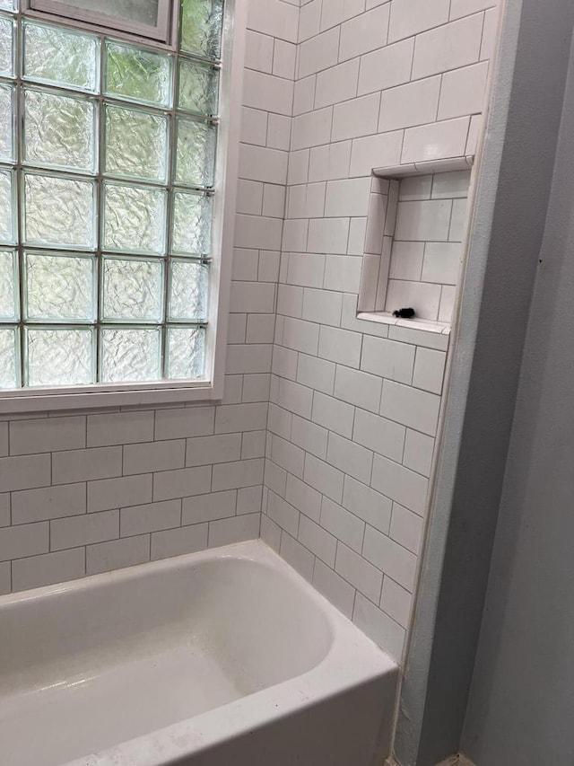 bathroom featuring tiled shower / bath