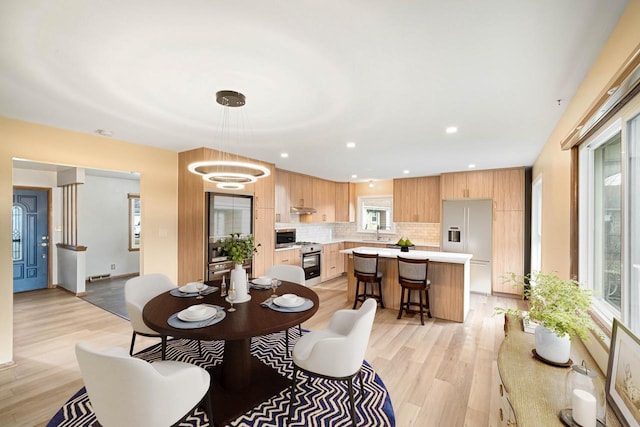 dining room with a chandelier, light hardwood / wood-style floors, and sink