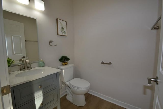 bathroom featuring hardwood / wood-style flooring, vanity, and toilet