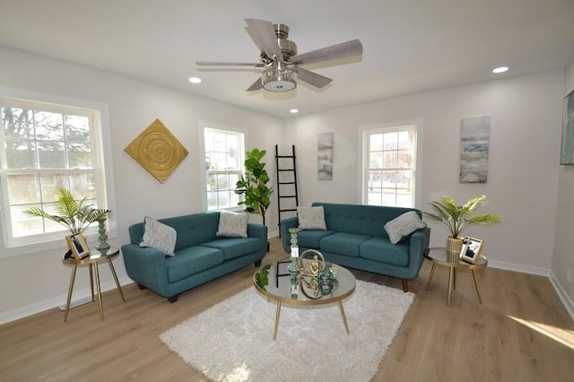 living room featuring ceiling fan, light hardwood / wood-style flooring, and a healthy amount of sunlight