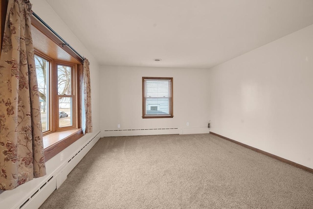 carpeted empty room with a wealth of natural light and a baseboard radiator