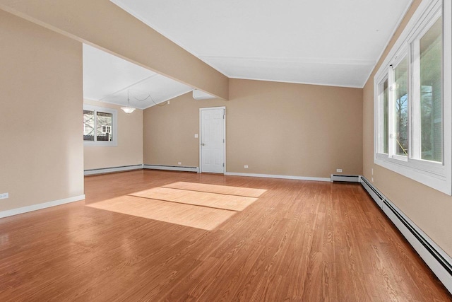 spare room featuring vaulted ceiling with beams, wood-type flooring, and a baseboard heating unit