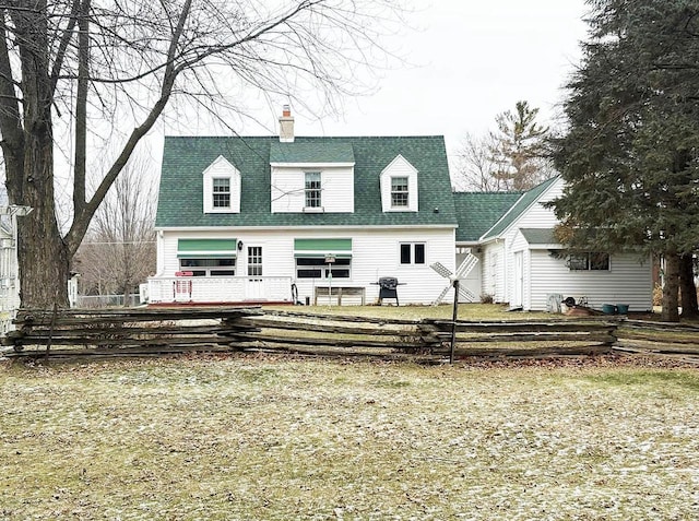 cape cod-style house featuring a front lawn