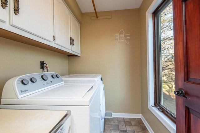 washroom with washer and clothes dryer and cabinets