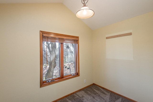 carpeted spare room featuring vaulted ceiling