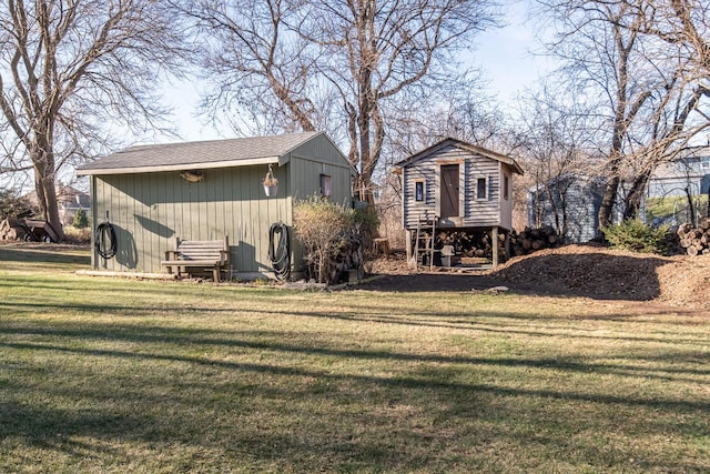 rear view of house with an outdoor structure and a lawn