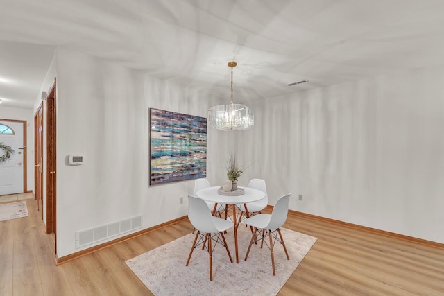 dining space with wood-type flooring and a chandelier