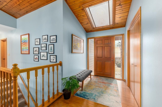 entrance foyer featuring light hardwood / wood-style flooring, vaulted ceiling, and wooden ceiling