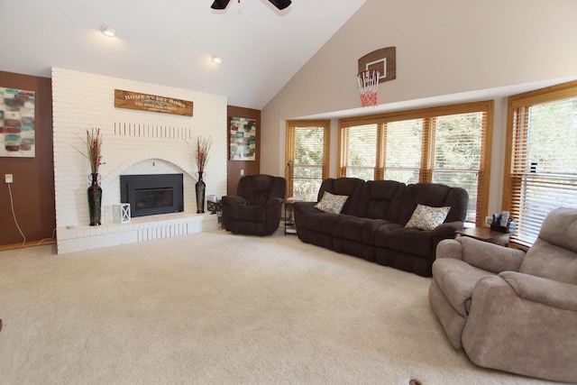 carpeted living room with ceiling fan, high vaulted ceiling, and a brick fireplace