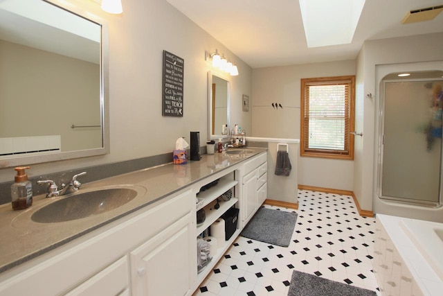 bathroom featuring vanity, an enclosed shower, and a skylight