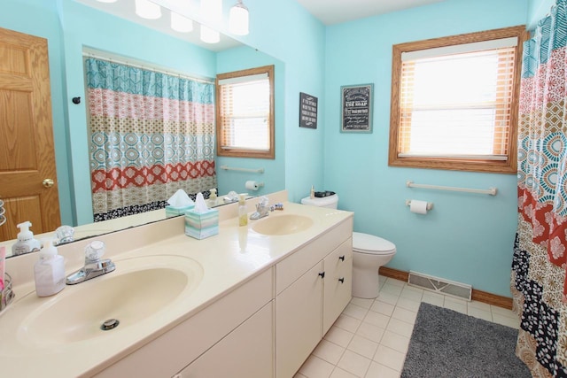 bathroom featuring tile patterned floors, plenty of natural light, vanity, and toilet