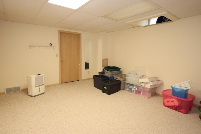 basement featuring carpet flooring and a paneled ceiling