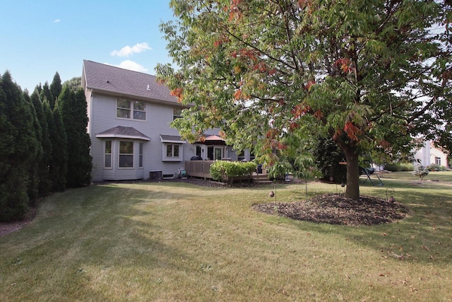 rear view of property featuring a yard and a deck