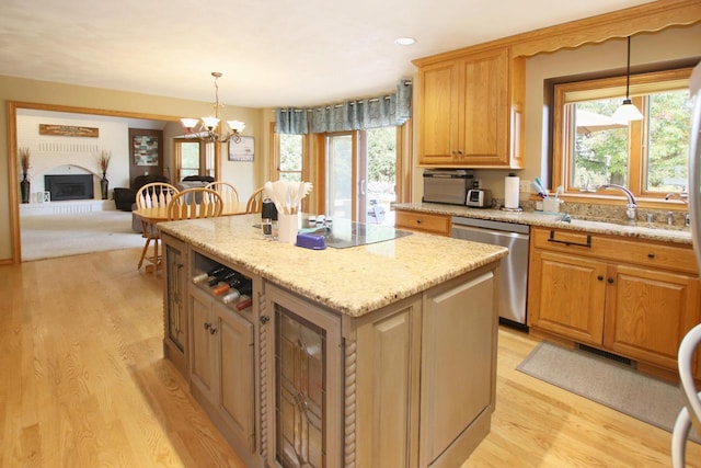 kitchen featuring a center island, decorative light fixtures, stainless steel dishwasher, and sink