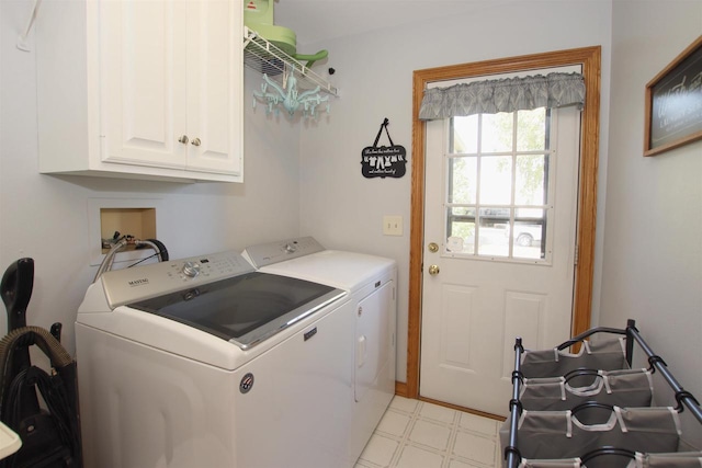 laundry area featuring washer and dryer and cabinets