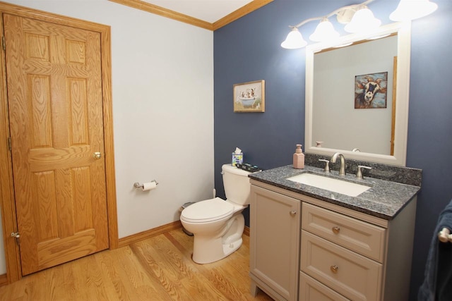 bathroom featuring vanity, hardwood / wood-style flooring, toilet, and ornamental molding